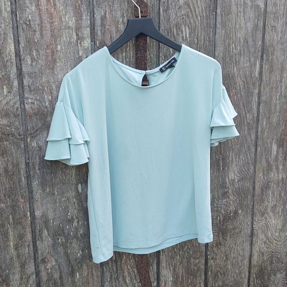 This is a pale aqua top made by International Conc